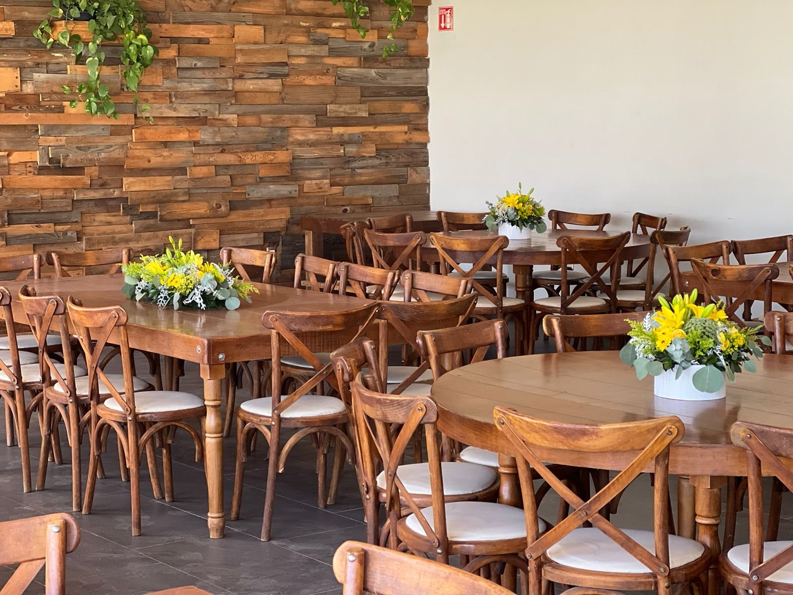 Salón cerrado con muro de madera y mesas de madera